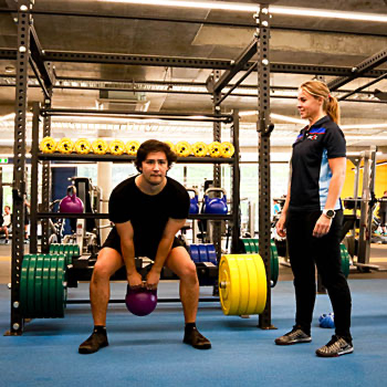 man doing a kettlebell front raise